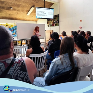 Grupo de pessoas apoiadas da Cercipeniche, junto a Psicóloga Cristina Ouazir em Workshop sobre o Autismo. Logotipos e elemento gráfico.