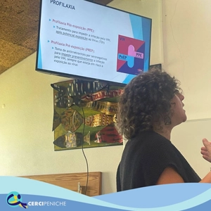 Foto Palestrante com pessoas apoiadas da Cercipeniche. Em palestra sobre a prevenção de infeções sexualmente transmissível. Logotipo e elemento gráfico.