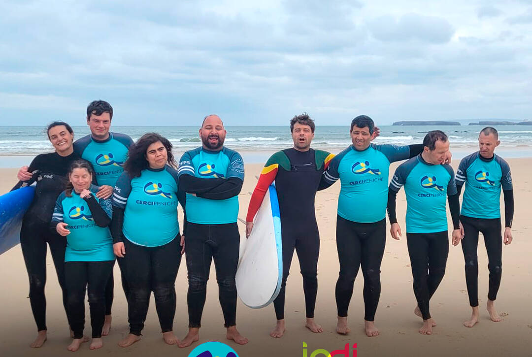 Pessoas apoiadas pela Cercipeniche com os instrutores da Escola de Surf de Peniche numa aula de surf na praia de Peniche