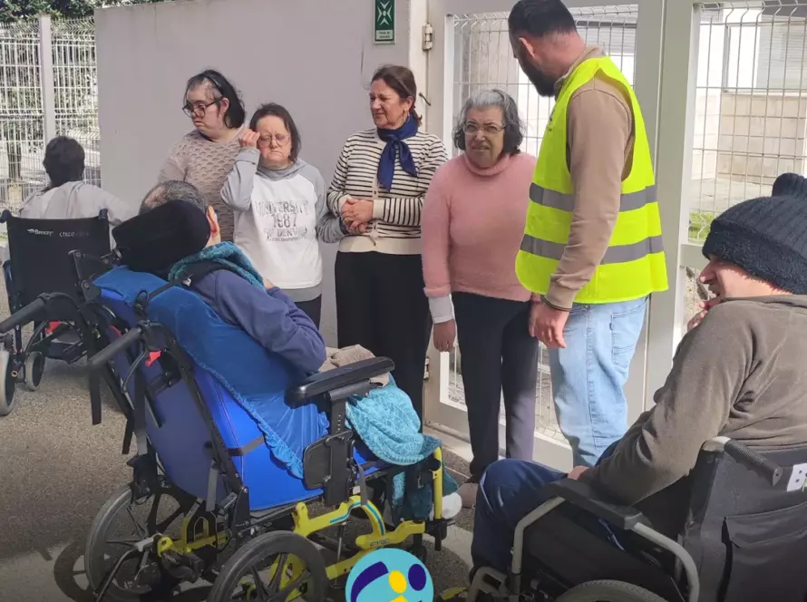Simulacro no Lar Residencial. Colaboradores e pessoas apoiadas pela Cercipeniche no ponto de encontro. Logo da Cercipeniche