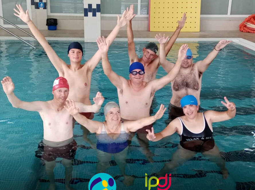 Pessoas apoiadas pela Cercipeniche na piscina, em contexto do projeto AQUA+, num momento de alegria. Logo da Cercipeniche.