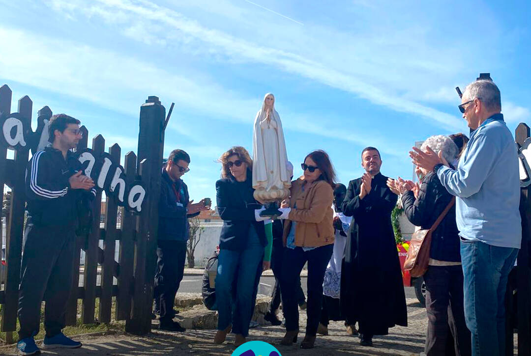 Imagem da N. Sra. de Fátima a ser transportada por duas colaboradoras da Cercipeniche, num momento de emoção. Logo da Cercipeniche.
