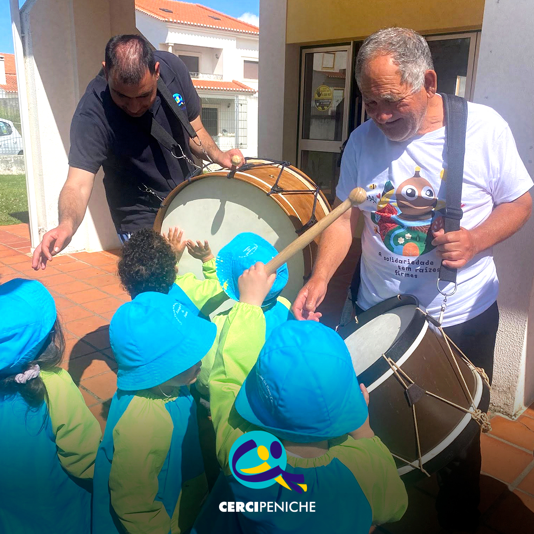 Pessoas apoiadas em interação com crianças do jardim de infância, num momento de convívio durante a campanha Pirilampo Mágico 2026. Logo da Cercipeniche.