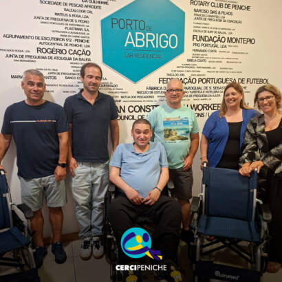 Membros da Associação Terra e Mar e elementos do Lar Residencial Porto de Abrigo posam para a fotografia. À frente encontram-se as três cadeiras de rodas oferecidas pela associação. Logo da Cercipeniche.