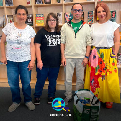 Pessoas apoiadas pela Cercipeniche, na Biblioteca Municipal de Peniche, recebem um saco com produtos alimentares doados, num gesto de solidariedade. Logo da Cercipeniche.