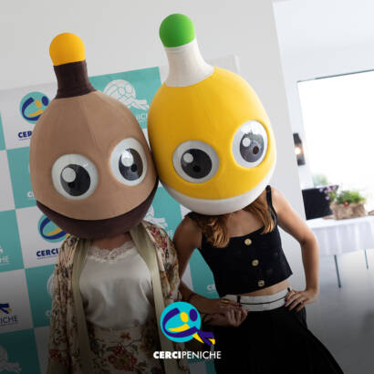 Pessoas com as mascotes do Pirilampo Mágico na cabeça, o castanho e o amarelo, durante o evento Sunset Pirilampo Mágico `26. Logo da Cercipeniche.