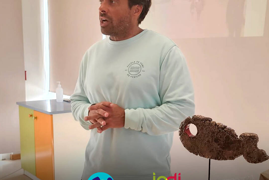 Calili durante a sessão, enquanto partilha conhecimentos e recomendações sobre segurança na água e no mar. Logo da Cercipeniche e do IPDJ.
