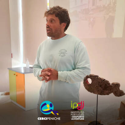Calili durante a sessão, enquanto partilha conhecimentos e recomendações sobre segurança na água e no mar. Logo da Cercipeniche e do IPDJ.