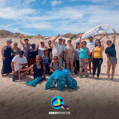 Fotografia de grupo na praia, no final da ação de sensibilização, com pessoas apoiadas pela Cercipeniche e elementos da Ocean Patrol. Logo da Cercipeniche.