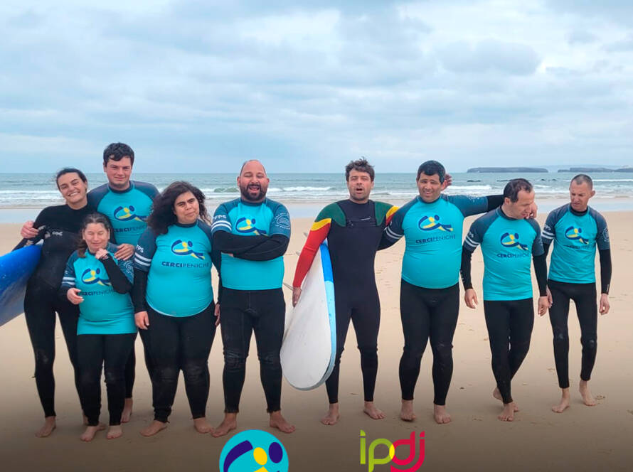 Pessoas apoiadas pela Cercipeniche com os instrutores da Escola de Surf de Peniche numa aula de surf na praia de Peniche