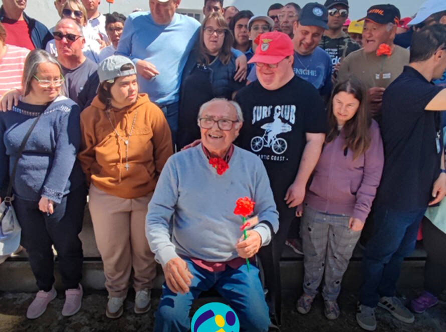 Foto de grupo com pessoas apoiadas pela Cercipeniche e o ex-preso político José Tavares Marcelino. Logo da Cercipeniche.