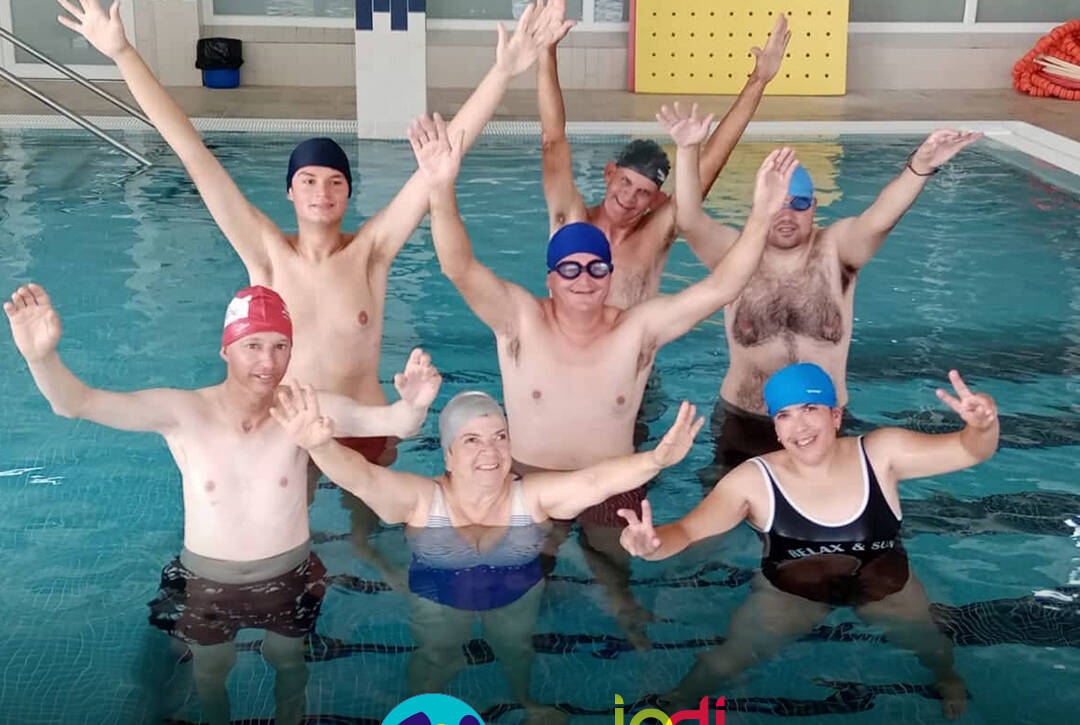 Pessoas apoiadas pela Cercipeniche na piscina, em contexto do projeto AQUA+, num momento de alegria. Logo da Cercipeniche.