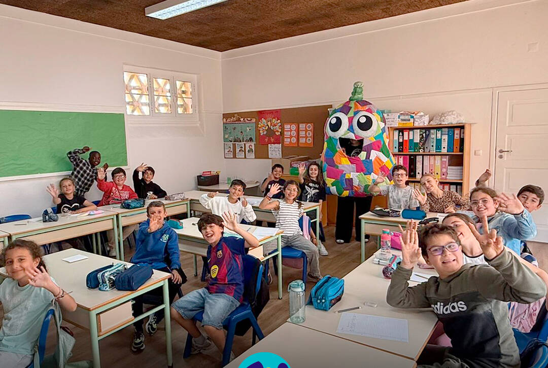 Foto com crianças dentro da sala de aulas, ao fundo está a mascote do Pirilampo Mágico. Logo da Cercipeniche.