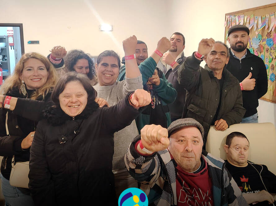 Grupo de pessoas apoiadas pela Cercipeniche animadas à chegada ao Festival Rock in Rei. Logo da Cercipeniche.