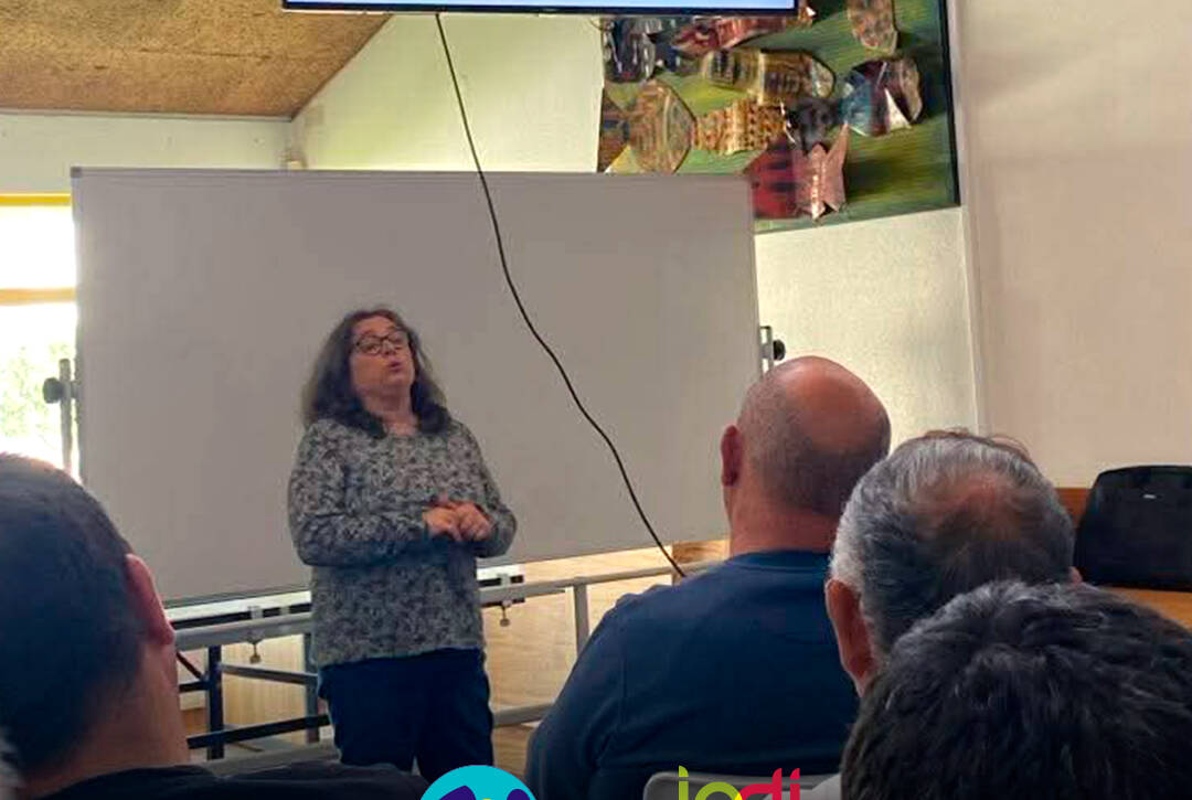 Enfermeira Cristina Costa a esclarecer os participantes durante uma sessão de esclarecimento na Cercipeniche. Logo da Cercipeniche.