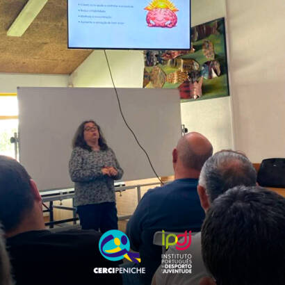 Enfermeira Cristina Costa a esclarecer os participantes durante uma sessão de esclarecimento na Cercipeniche. Logo da Cercipeniche.