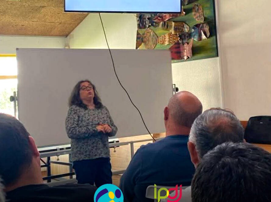Enfermeira Cristina Costa a esclarecer os participantes durante uma sessão de esclarecimento na Cercipeniche. Logo da Cercipeniche.