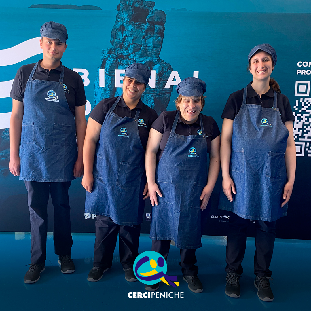 Grupo de participantes pousam para a foto, felizes, antes do início da atividade na Bienal do Mar. Logo da Cercipeniche.