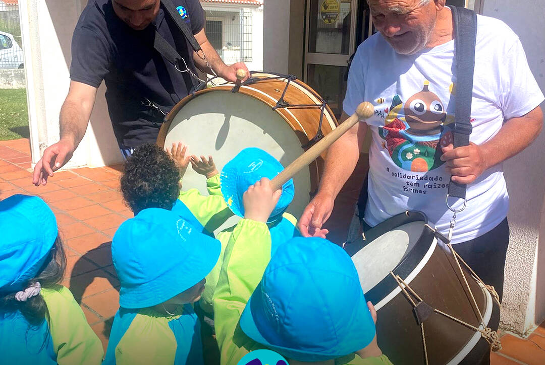 Pessoas apoiadas em interação com crianças do jardim de infância, num momento de convívio durante a campanha Pirilampo Mágico 2026. Logo da Cercipeniche.