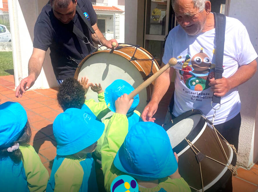 Pessoas apoiadas em interação com crianças do jardim de infância, num momento de convívio durante a campanha Pirilampo Mágico 2026. Logo da Cercipeniche.