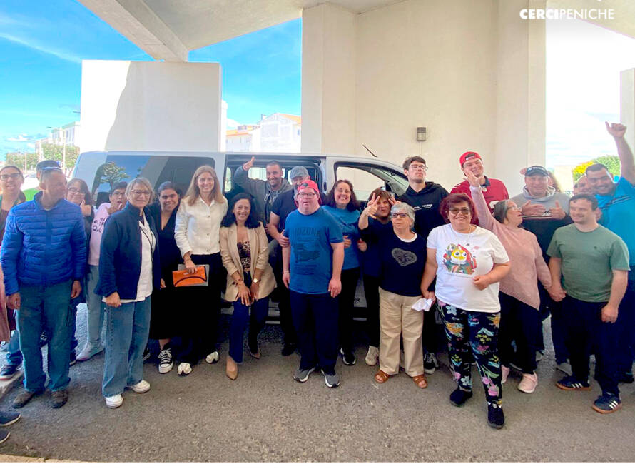 Todos reunidos em frente à nova carrinha elétrica da instituição, num momento de celebração e alegria. Logo da Cercipeniche e barra de financiamento do PRR.