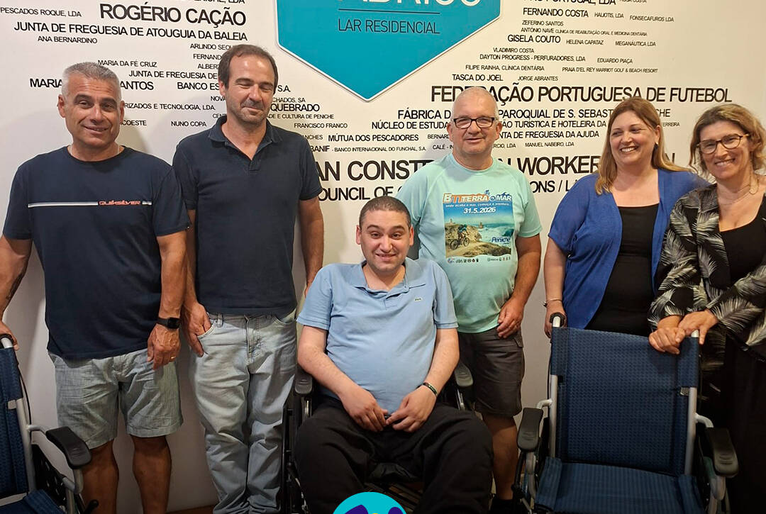 Membros da Associação Terra e Mar e elementos do Lar Residencial Porto de Abrigo posam para a fotografia. À frente encontram-se as três cadeiras de rodas oferecidas pela associação. Logo da Cercipeniche.