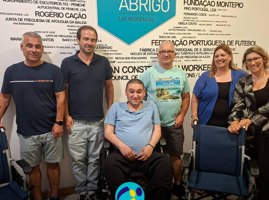 Membros da Associação Terra e Mar e elementos do Lar Residencial Porto de Abrigo posam para a fotografia. À frente encontram-se as três cadeiras de rodas oferecidas pela associação. Logo da Cercipeniche.