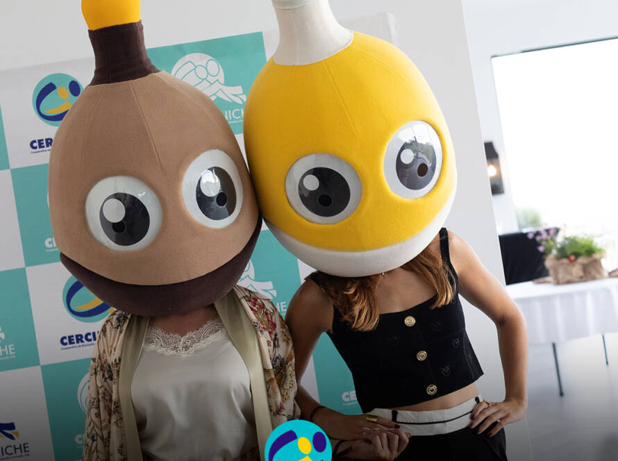 Pessoas com as mascotes do Pirilampo Mágico na cabeça, o castanho e o amarelo, durante o evento Sunset Pirilampo Mágico `26. Logo da Cercipeniche.