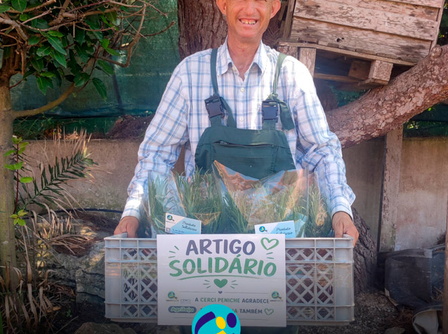 Pessoa apoiada pela Cercipeniche a mostrar as caixas com as alfazemas para entrega na Agriloja de Peniche. Logo da Cercipeniche.