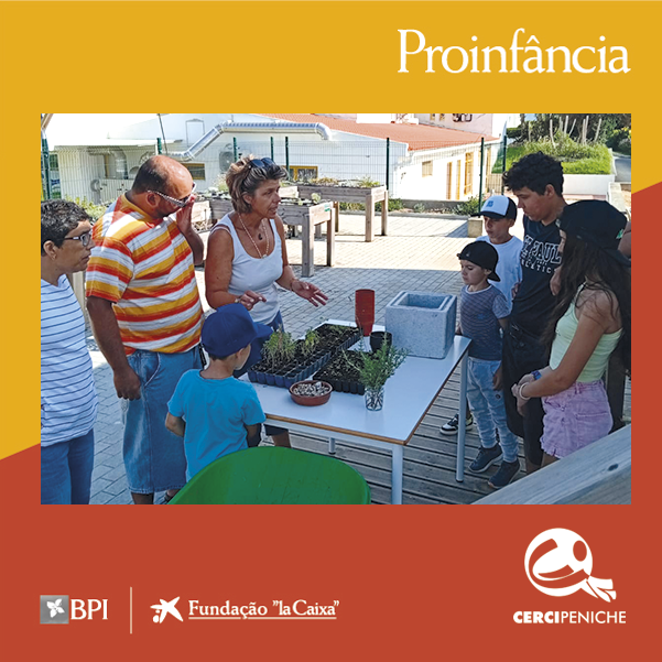 Um grupo de crianças e adultos reunidos à volta de uma mesa, no exterior das instalações da Cercipeniche. A monitora explica a atividade “Mãos na Terra” ao grupo. Sobre a mesa encontram-se várias plantas, pequenos vasos, recipientes com terra e outros materiais utilizados na atividade. As crianças observam a explicação. A imagem tem uma moldura gráfica amarela e laranja. Na parte superior aparece a palavra “Proinfância”. Na parte inferior aparecem os logótipos do BPI, da Fundação “la Caixa” e da Cercipeniche.