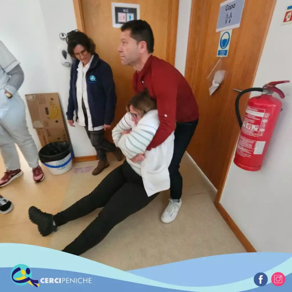 Colaboradoras da Cercipeniche, com o Formador dos Bombeiros, no Simulacro no edifício CERIN